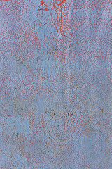 Texture of old peeling and cracked paint. Red is visible under blue