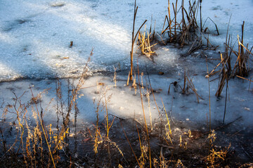 frozen pond in spring at sunset