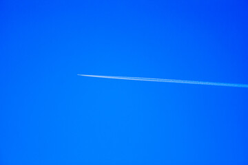 airplane at high altitude at sunset on blue sky