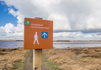 Sign for the one way Knuppelpad walking path over the lake in Roegwold, Netherlands