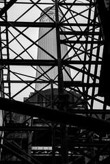 Close-up of an Old Rusty Metal Frame With a Chimney in the Background