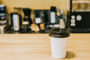 A paper coffee cup is on the counter in a coffee shop. Morning concept, coffee to go.