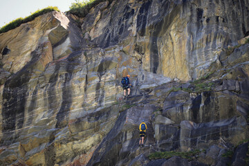 6.07.2020 - Austria Three ferrata climbers try to climb a rock along Stausee Mooserboden dam in Austrian resort of Kaprun in Zell am see District. Dangerous sport involving special climbing equipment