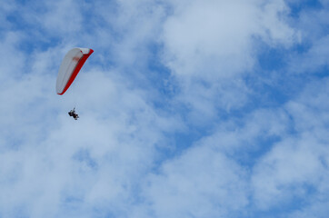 Flying on a paraglider. Paraglider with two passengers on a background of blue sky