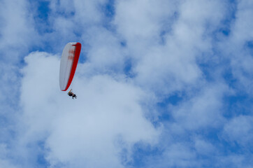 Flying on a paraglider. Paraglider with two passengers on a background of blue sky