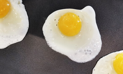 fried eggs on black background