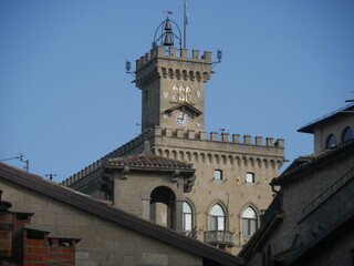 Fototapeta premium San Marino, Public Palace. Closeup on the crenellated clock tower with the mosaic and the coats of arms of the four Castles of the Republic