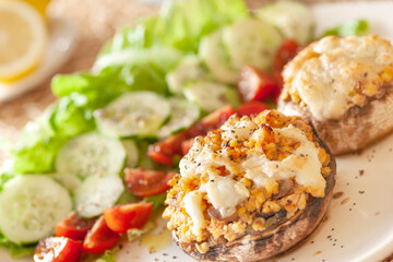 Mediterranean food. Stuffed mushrooms whith cheese, salad, tomato, cucumber, lemon.