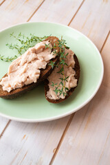 Homemade meat snack chicken liver pate with savory and olives on slices of dark bread