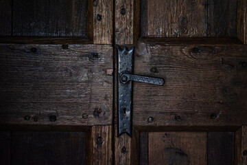 dettaglio di porta di legno antica con maniglia di ferro
