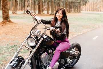 Plakat beautiful brunette riding a motorcycle in the park