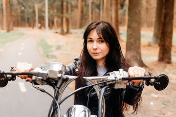 beautiful brunette riding a motorcycle in the park