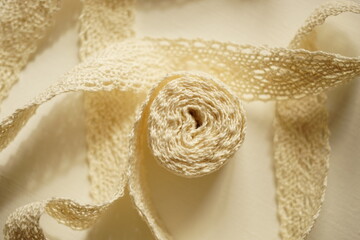 Delicate beige lace on a white table. Top view.