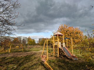 gray clouds on blue sky over yellow children's playground