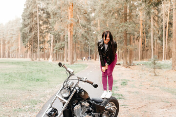 Fototapeta na wymiar beautiful brunette riding a motorcycle in the park