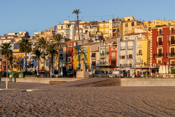 View of the colorful houses of the town of Villajoyosa from its beach at sunrise.