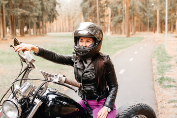 beautiful brunette riding a motorcycle in the park
