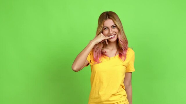 Young blonde woman making phone gesture and speaking with someone. Call me back sign over isolated background