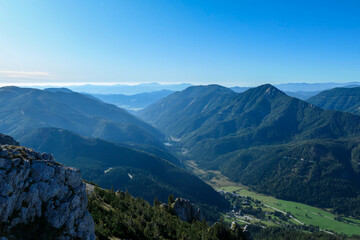 The view on the Alpine valley from the way to Hohe Weichsel in Austria. There is a dense forest on the steep slopes. View on Hochschwab. Clear and bright day. Calmness and peace.