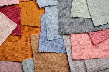Scraps of natural flax of different colors. pink, gray, blue, mustard, brown, burgundy. Fashionable color palette of natural fabrics. Macro shooting. Top view.