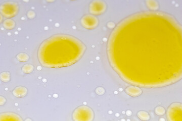 Naklejka na ściany i meble yellow liquid bubbles on white background, abstract chemical scientific background