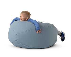 Little happy boy lying on his stomach on a bean bag isolated on white background