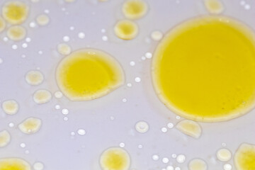 Naklejka na ściany i meble yellow liquid bubbles on white background, abstract chemical scientific background