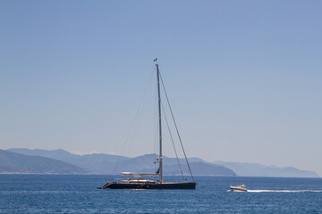 Obraz premium Yachts at sea against the backdrop of the outlines of the mountains.