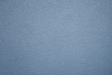 A simple texture of blue-gray background in the form of a rough grainy coating with putty or plaster on a flat surface
