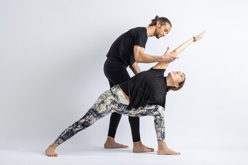 Extended Side Angle Pose (Utthita Parsvakonasana) . Yoga teacher correcting a student's posture.