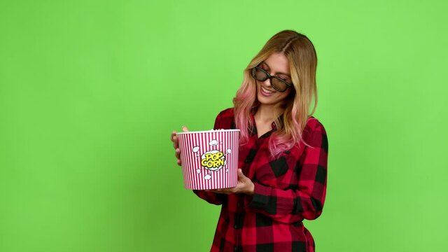 Young blonde woman eating popcorns in a big bowl over isolated background on green screen chroma key