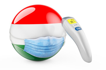 Hungarian flag with medical mask and infrared electronic thermometer. Pandemic in Hungary concept, 3D rendering