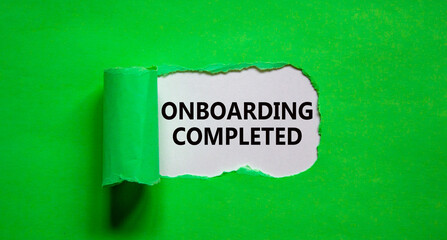 Onboarding completed symbol. Words 'Onboarding completed' appearing behind torn green paper. Beautiful green background. Business, onboarding completed concept, copy space.