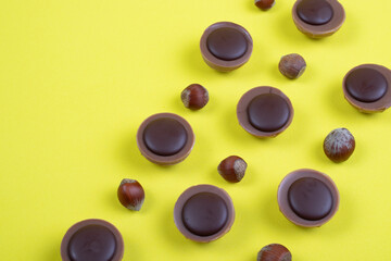 caramel sweets and hazelnuts on a yellow background