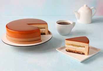 Mousse cake on the table with a cup and a teapot