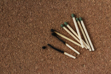 Burnt and  whole green matches on a cork background. Close-up 