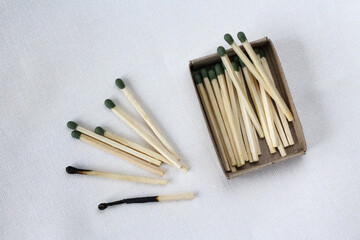 Fototapeta na wymiar Open matches box with green matches. Close-up of a burnt and whole matches