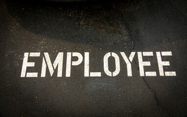 Sign stating Employee stenciled on asphalt