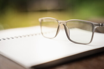Classic eye glasses on white notebook, idea, innovation and inspiration concepts.