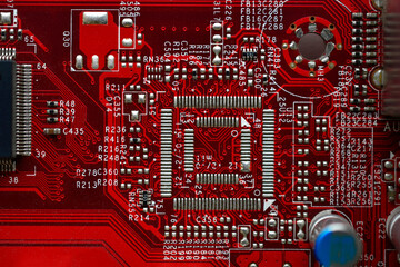 Red computer motherboard chip close-up with elements