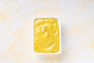 American mustard in a bowl on yellow cement background