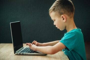 Naklejka premium boy doing computer lessons on a dark background