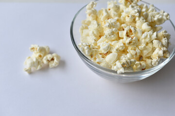 Glass saucer with popcorn on a white background