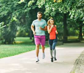 Obraz premium fitness woman park exercise lifestyle outdoor sport healthy couple nature active young fit training athlete man