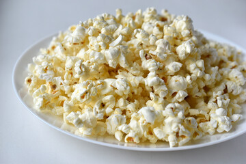Delicious popcorn on a white plate close-up