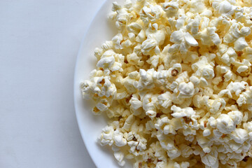 Delicious popcorn on a white plate close-up
