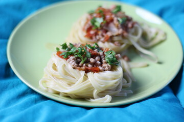 spaghetti nests with meat farce, tomato sauce on green plate 