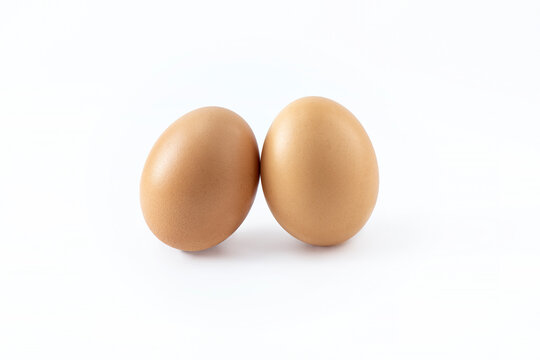A pair of eggs on a white background. Isolated image of chicken eggs. Scrambled eggs, diet food preparation. Easter theme