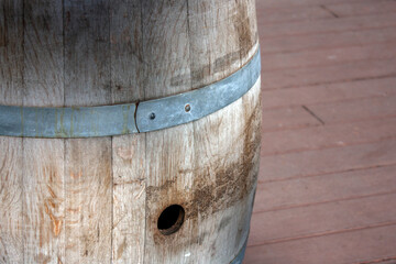 Wooden barrel close-up. Steel hoop on a wooden barrel, side view. View of a fragment of a wooden barrel on a sunny day.