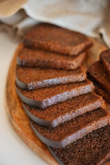 Black Borodino bread, cut into pieces, lies on a wooden board